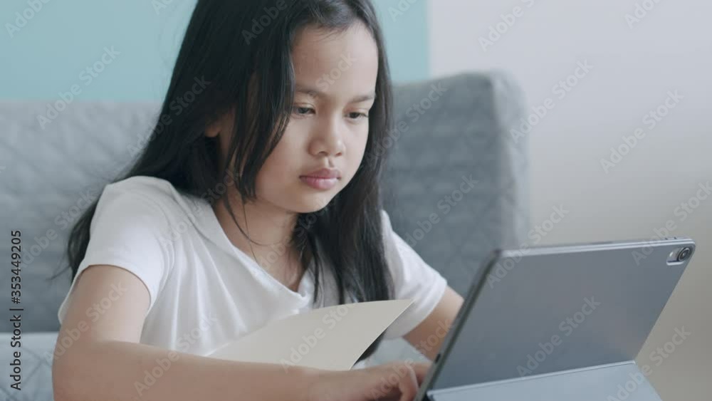 Asian little girl using tablet internet learn online at home morning Asian little girl using tablet internet learn online at home morning