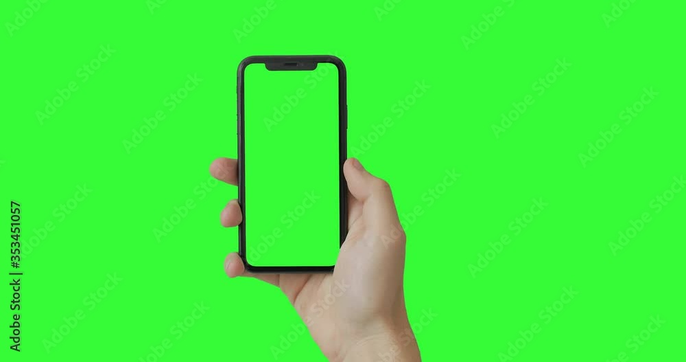 Man hand holding the smartphone on green screen chroma key background. Mobile phone mock-up for your product. The iPhone Xr model in vertical orientation portrait mode. Man hand holding the smartphone on green screen chroma key background. Mobile phone mock-up for your product. The iPhone Xr model in vertical orientation portrait mode.