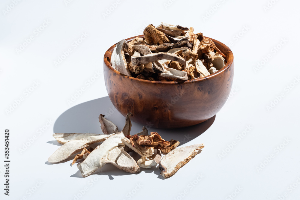 dried mushrooms in a wooden bowl isolated on white dried mushrooms in a wooden bowl isolated on white