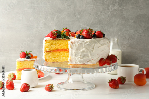 Composition with delicious berry cream cake against gray background. Tasty dessert
