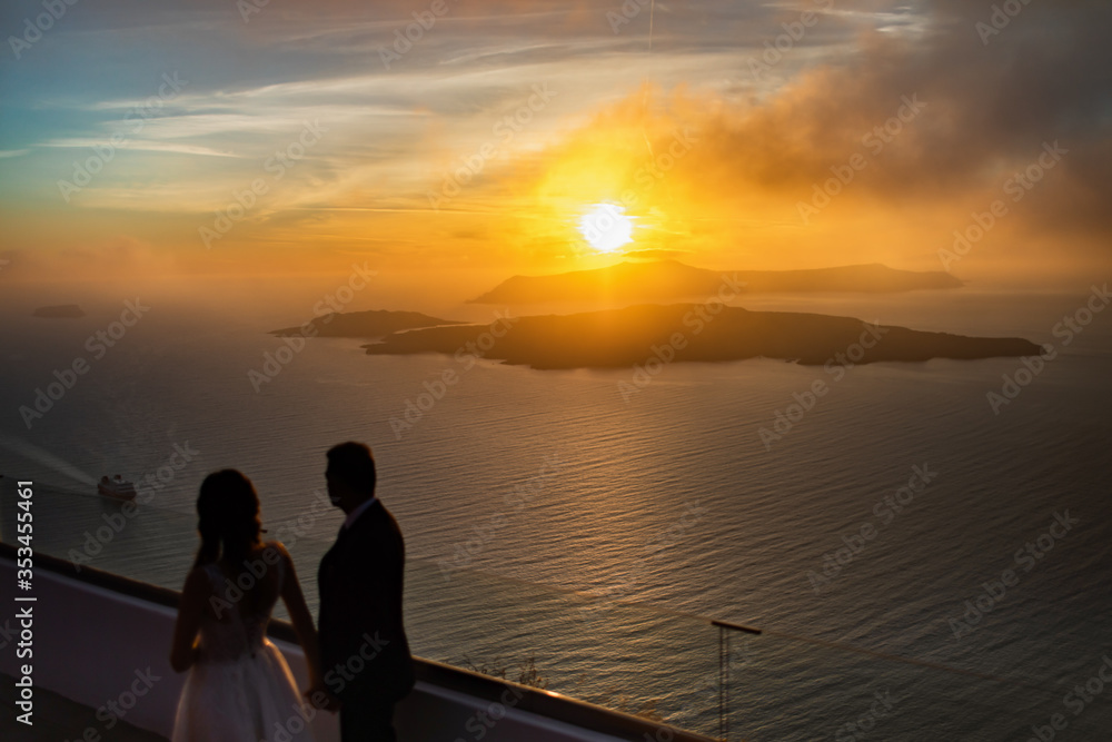 Silhouette of a loving couple on the background of the setting sun, mountains, islands and sea. Santorini. Greece. Just married. Walk. Silhouette of a loving couple on the background of the setting sun, mountains, islands and sea. Santorini. Greece. Just married. Walk.