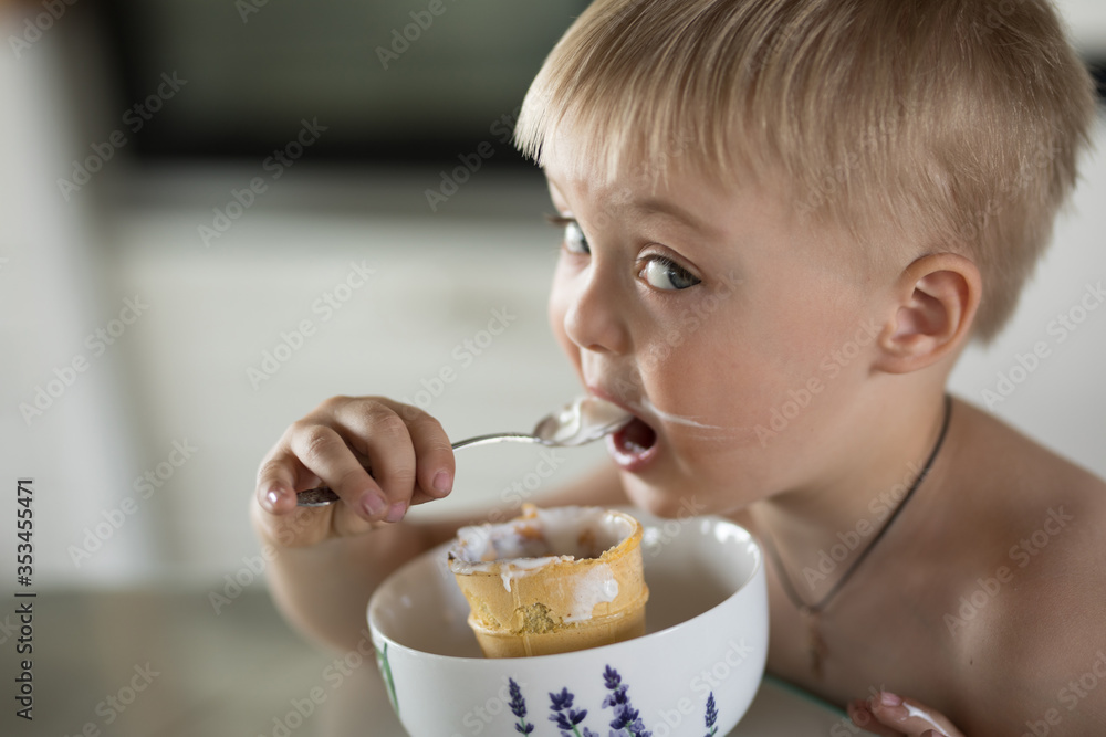 Little boy eats a spoon of ice cream