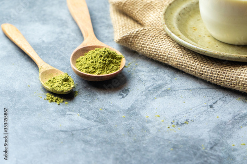 Green tea matcha powder on a  wooden spoon.