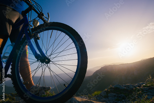Fototapeta Naklejka Na Ścianę i Meble -  Close up silhouette of an athlete (mountain biker) riding his bike on rocky mountains.
