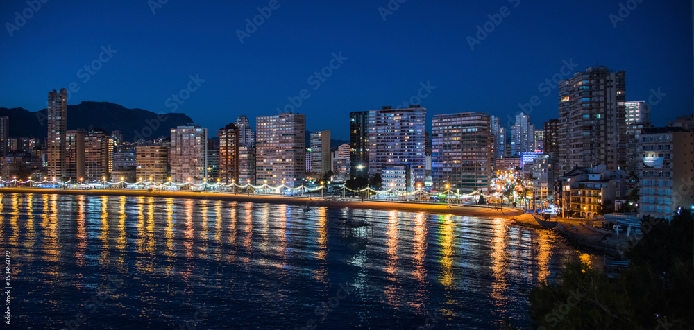 Night city by the sea with an empty beach and beautiful night lighting, Summer background