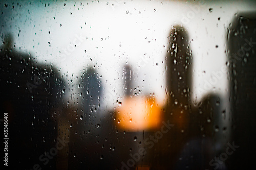 Raindrops on glass with blurred backdrop of skyscrapers