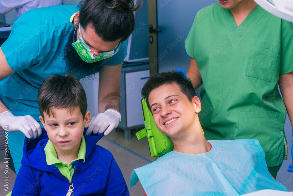 Professional dentist team and two young boys as patients at the dental office Professional dentist team and two young boys as patients at the dental office