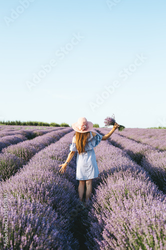 Girl with a hat on her head in the lavender field