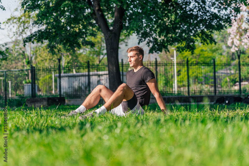 Athletic sportsman taking a break from a workout in the park