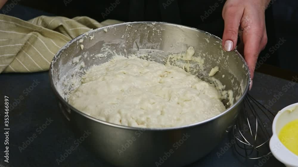 closeup woman hands move deep metal bowl with homemade white yeast dough closeup woman hands move deep metal bowl with homemade white yeast dough