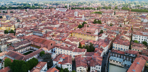 Landmarks of Italy - medieval town Lucca in Tuscany. Aerial view to the city. Buildings with tiled roofs. Beautiful landscape and cityscape. Postcard Italian concept. Tower and historical houses.