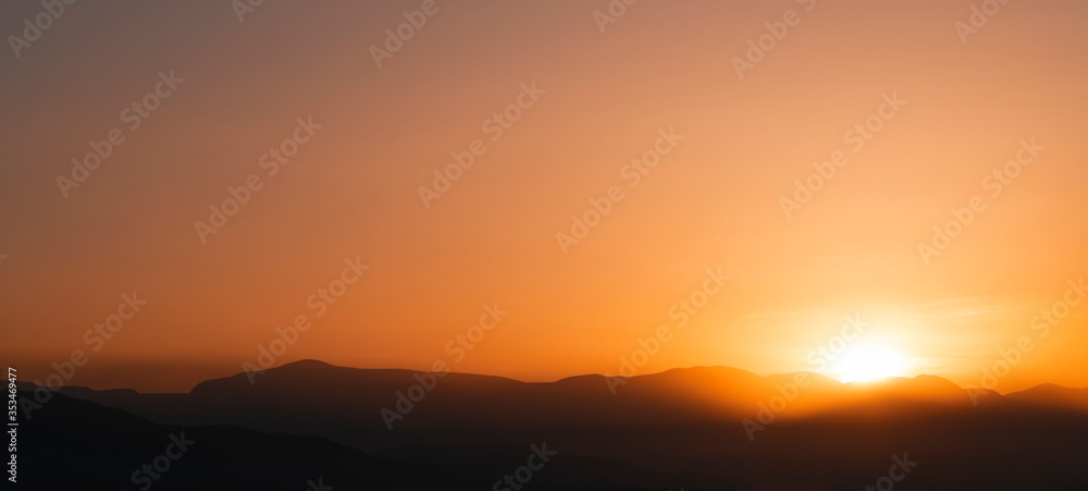 Beautiful bright sunrise sky over the mountains silhouette . Nature backgrounds
