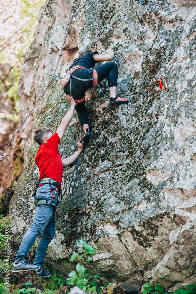 Climbing training. A girl climbs on a rock
