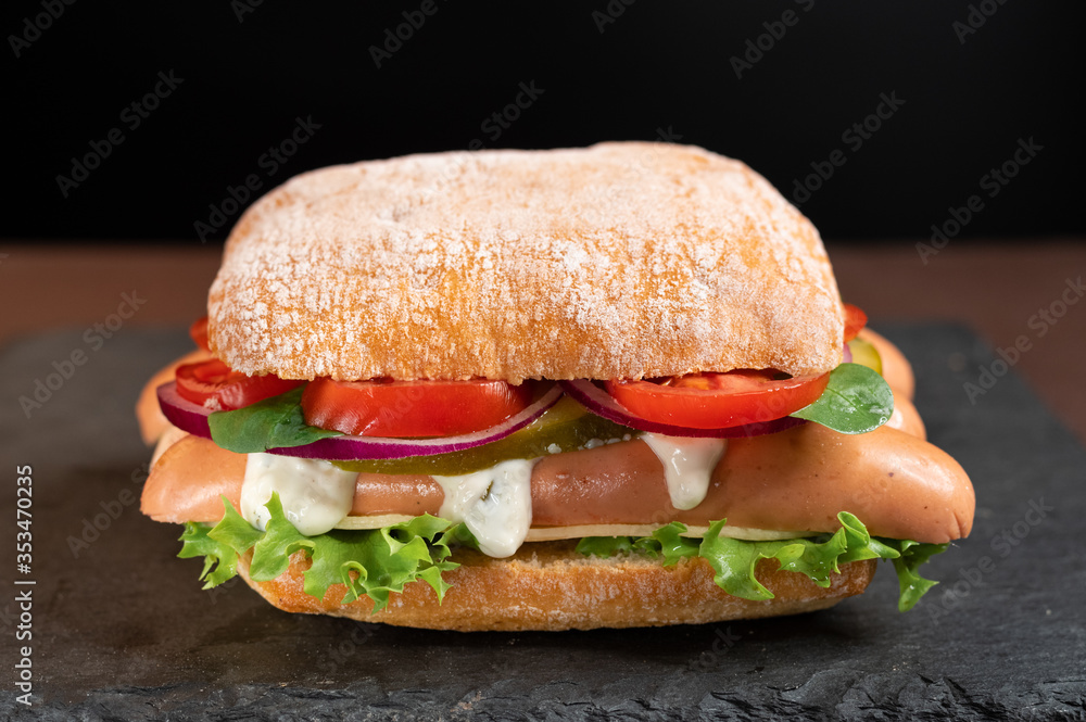 Sandwich with sausages and vegetables. Square roll with sausages and sauce. Sandwich with sausages and vegetables. Square roll with sausages and sauce.
