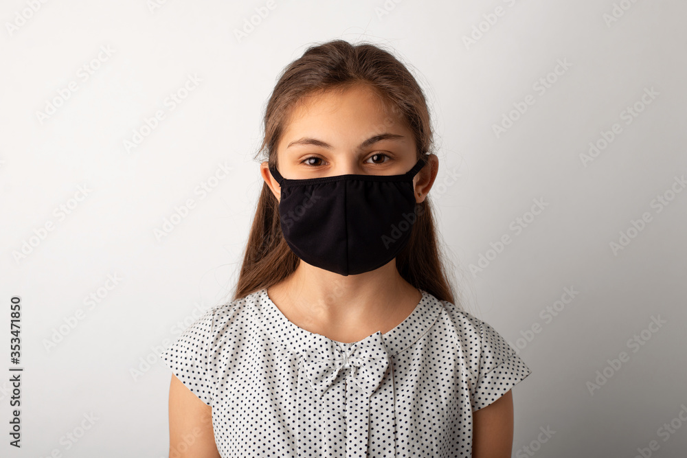 Epidemic concept. Portrait of a small girl in black medical mask in studio Epidemic concept. Portrait of a small girl in black medical mask in studio