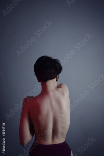young woman with naked back over Blue background. sport body gir.