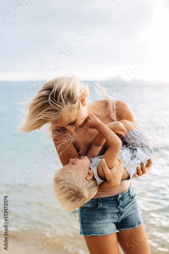 Foto Happy mom on vacation hugs her little laughing son