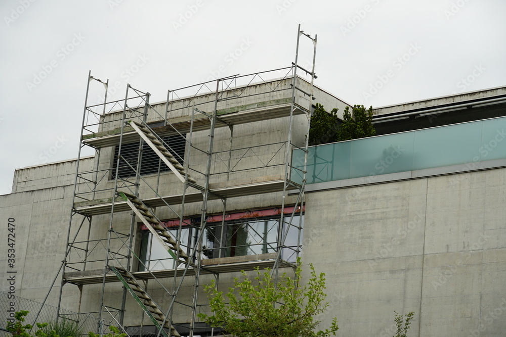 residential building, modern and small with scaffolding on one of the walls  with balconies to repair the terraced roof close up 