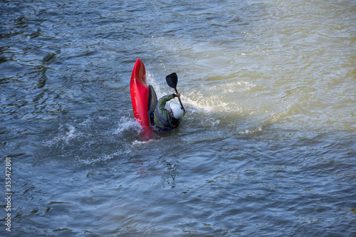 Fotografie Man in capsizing kayak; kayak skills training in high-water river; Struma River,