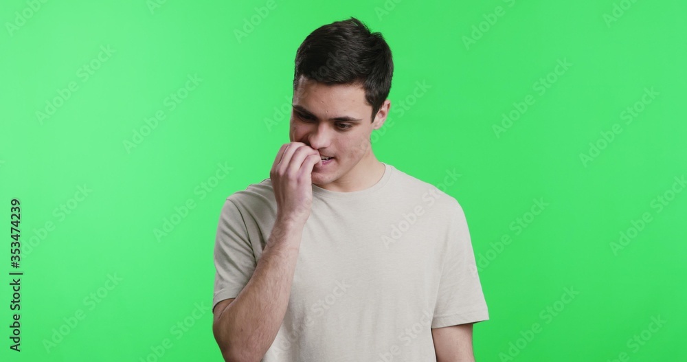 Nervous young man biting his nails uncontrollably Nervous young man biting his nails uncontrollably