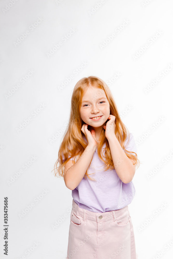 cute red-haired girl in ordinary clothes touches her hair and smiles cute red-haired girl in ordinary clothes touches her hair and smiles