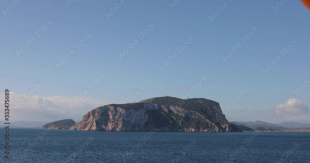 A peninsula with massive cliffs of a coastline as seen from a boat out on the water of an ocean. A peninsula with massive cliffs of a coastline as seen from a boat out on the water of an ocean.