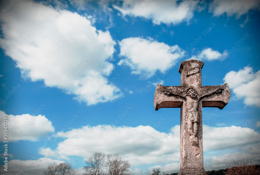 Beautiful very old and ancient statue of the crucifixion of Jesus Christ against blue sky. Free copy space.