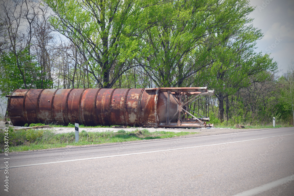 Old rusty metal construction near the road. Abandoned tank. Crisis concept. Old rusty metal construction near the road. Abandoned tank. Crisis concept.