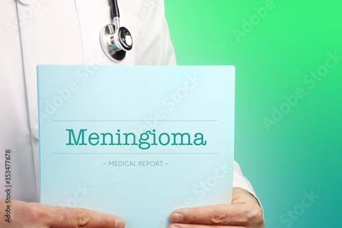 Meningioma. Doctor holds documents in his hands. Text is on the paper/medical report. Green background. photo