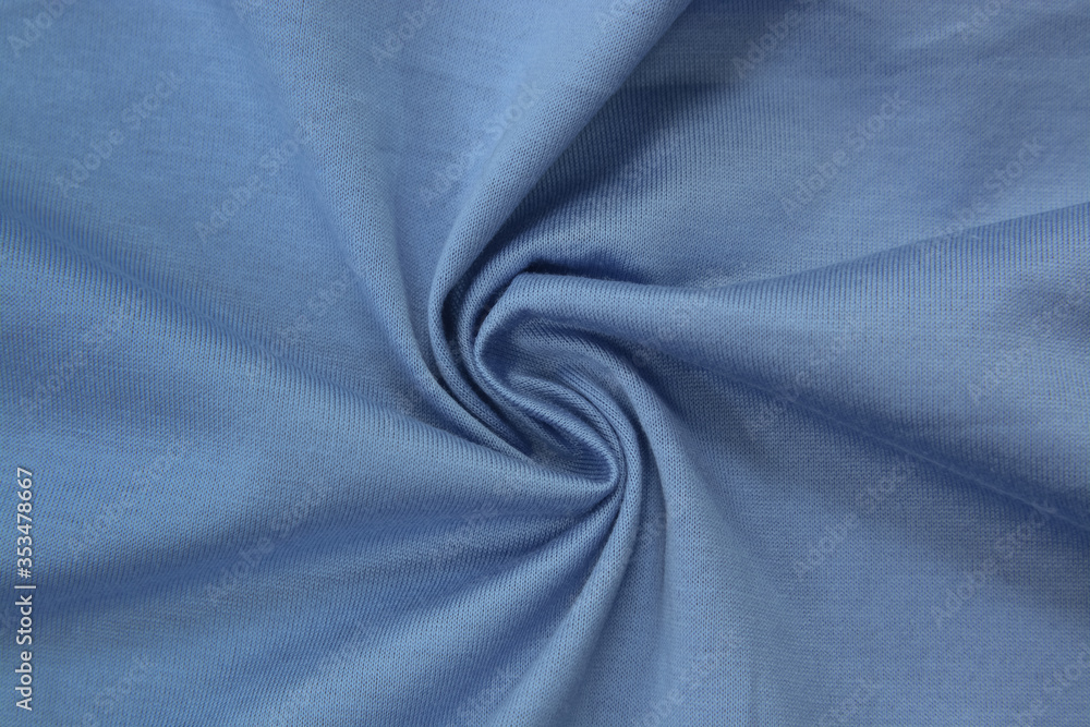 Fototapeta premium Light blue background of fabric from a piece of crumpled clothes. Top view. crumpled polyester. The texture of the fabric, useful as a backdrop.