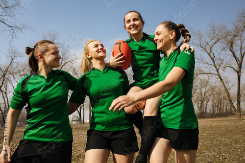 Rugby female players lifting the teammate after winning the game. Rugby team celebrating the victory