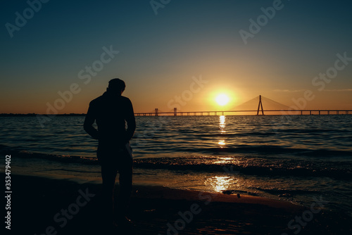 silhouette of a man walking on the beach, Background the Bandra-Worli Sealink bridge, Mumbai City, Beautiful Sunset