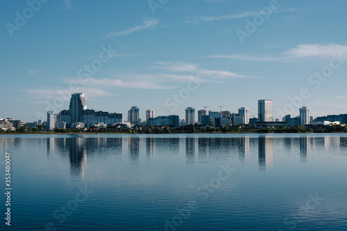 panorama of the city under construction against the blue sky and a large lake. buildings against the river and sky. panorama of Minsk. panorama city under construction