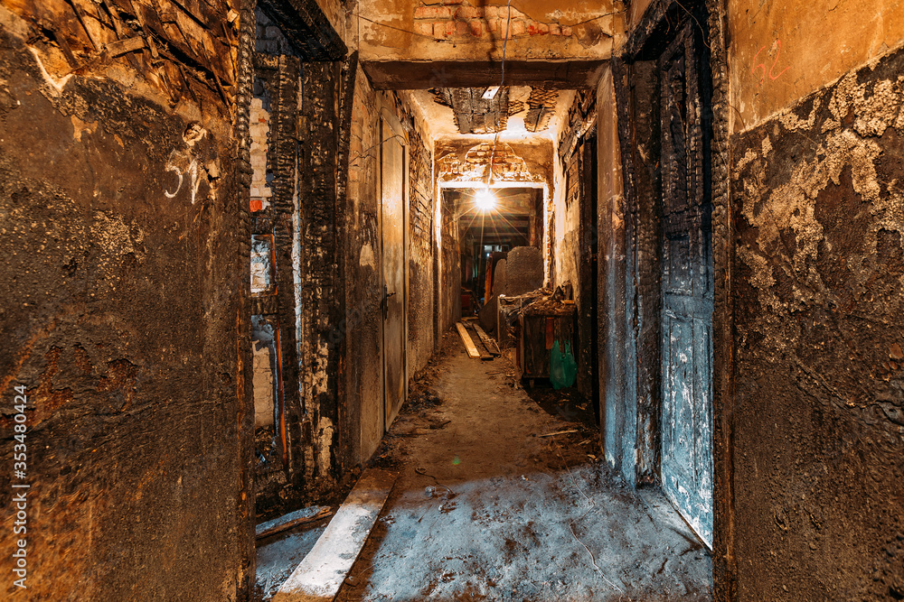 Burnt old house interior. Ruined coridor walls in black soot. Consequences of fire Burnt old house interior. Ruined coridor walls in black soot. Consequences of fire