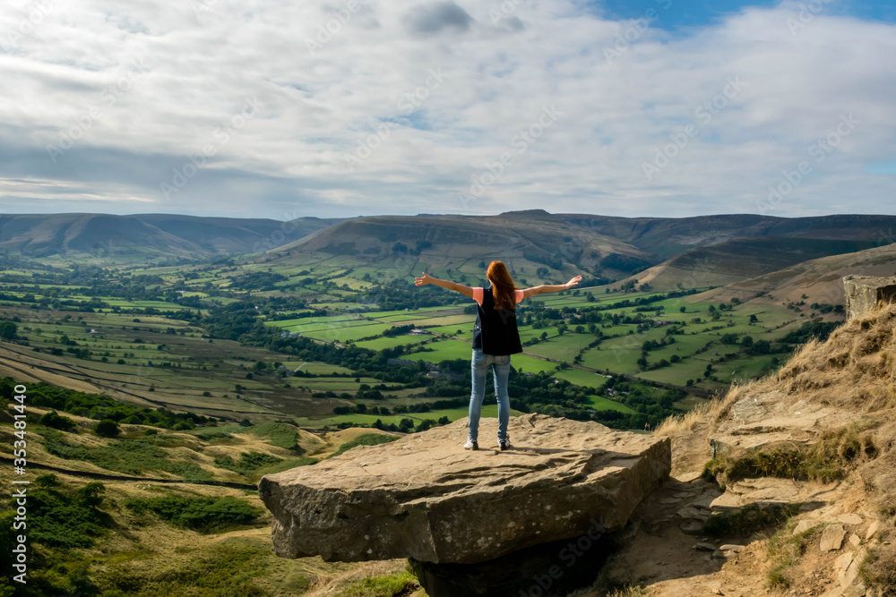 Yound girl stands on the rock and look on the valley, Valley in Peak District, UK