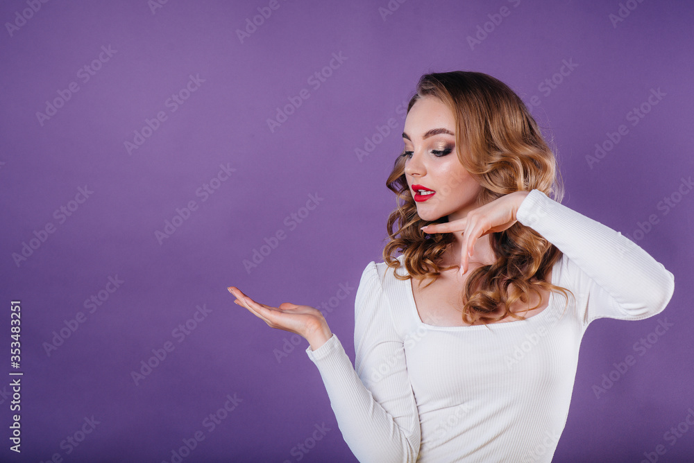 A young beautiful girl shows emotions and smiles in the Studio on a purple background. Girls for advertising A young beautiful girl shows emotions and smiles in the Studio on a purple background. Girls for advertising