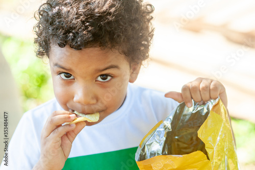Close up of a young boy eating a potato chip. Great copy space.