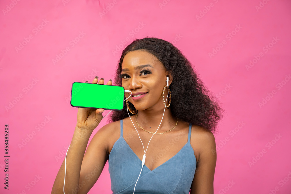 pretty young african woman showing her phone screen, wearing headphones
