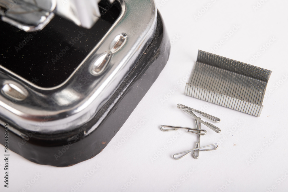 Stapler for fastening sheets of paper and staples. Office accessories for working behind the desk. Light background. Stapler for fastening sheets of paper and staples. Office accessories for working behind the desk. Light background.