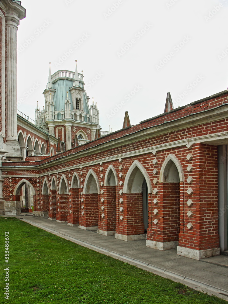 Moscow / Russia – 07 16 2019: Grand Palace right side arch wall on Grand Cavalier House background in Tsaritsyno Park Museum on summer day, architecture ancient landmark