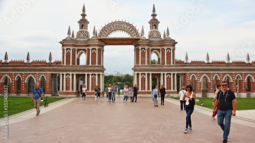 Moscow / Russia – 07 16 2019: Grand Palace beautiful central gate arch  with tourists people on alley in Tsaritsyno Park Museum on summer day, architecture ancient landmark
