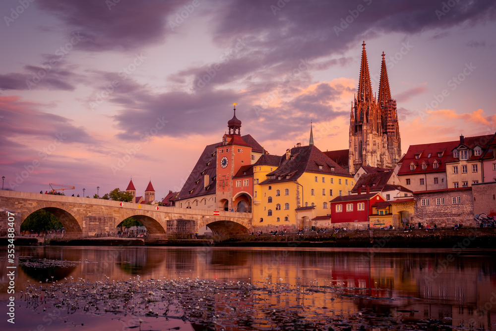 Stone bridge and cathedral of Regensburg from very low perspective at sunset