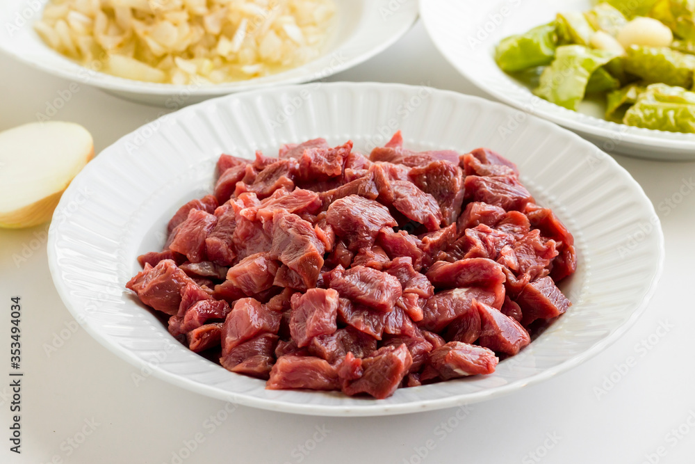 Uncooked,chopped beef meat ready for cook in plate.Festive braised meat ingredients. Uncooked,chopped beef meat ready for cook in plate.Festive braised meat ingredients.
