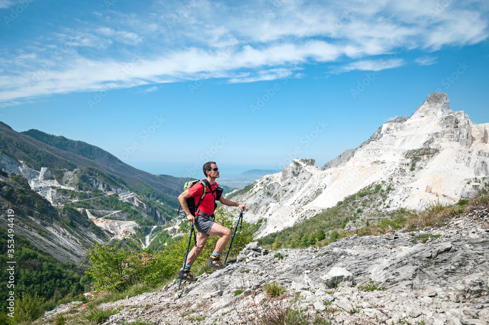panoramic landscape of a man trekking over the white marble quarries of Carrara