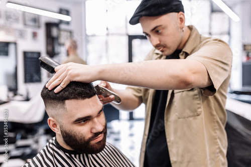 Classic haircut in a barbershop. Curve hair styling and hair health care in a barbershop. 
