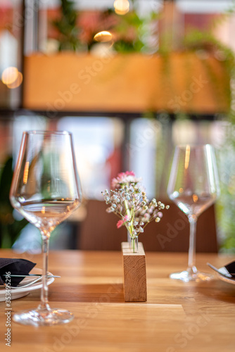 Decorative flowers on the table in the restaurant with wine glasses