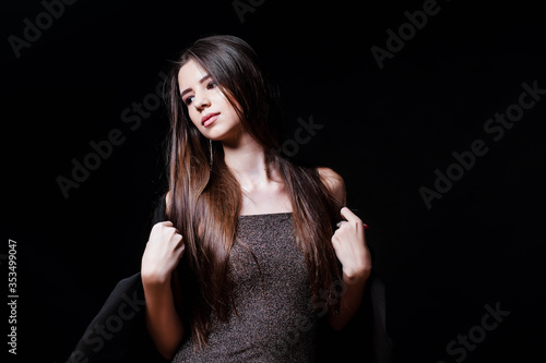 Young woman in a dress touches her hair isolated on black. Okay. Hair. The girl in the dress. Fashion. Natural cosmetics and beautiful bright makeup. Beautiful young girl. Portrait of a girl.