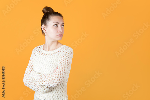 girl with resentment looks at someone over her shoulder, hands clasped on her chest