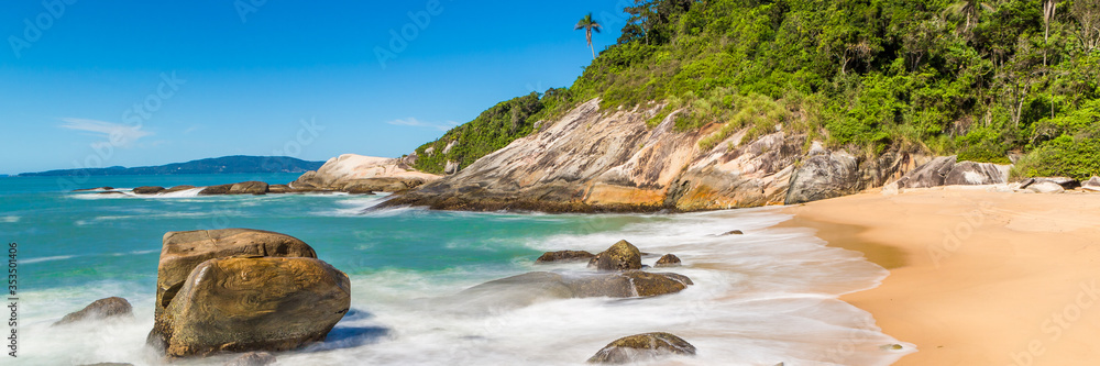 Tropical beach with panoramic views and waves, rocks and sand background. Travel destinations in Brazil and banner web.