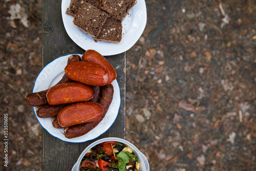 Sausages, bread and salad - food to prepaire on a fire. Concept of outdoor cooking. photo